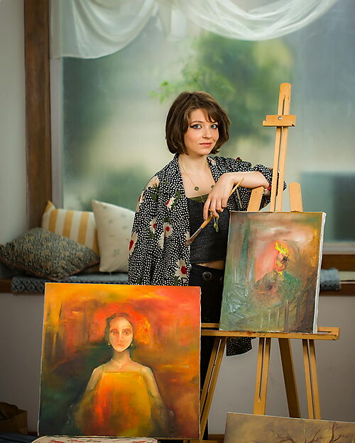 Frau präsentiert ein Kunstwerk in einer Ausstellung – Symbolbild für Leserbeiträge, Teilen und Community rund um Malen nach Zahlen.