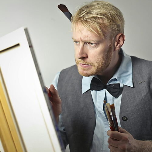Konzentrierter Mann malt auf einer Leinwand im Studio – Symbolbild für geführtes Malen und kreative Praxis.