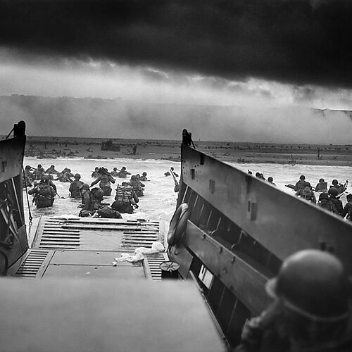 Fotografie oben: Taxis to Hell – and Back – Into the Jaws of Death, von Robert F. Sargent, CPhoM,Amerikanische Invasoren springen von der Rampe eines Landungsbootes
