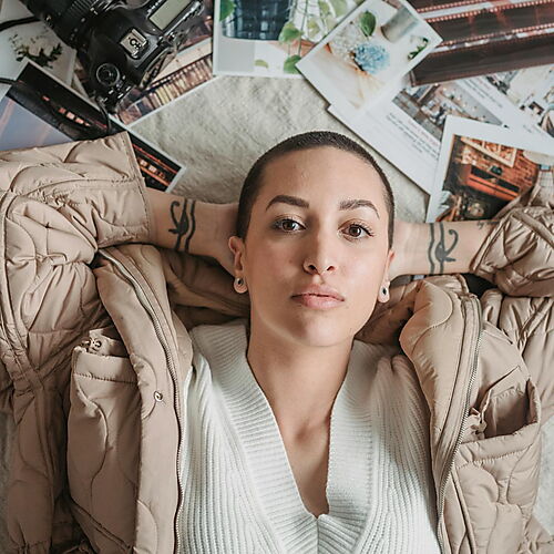 Junge Frau auf mehren Fotos und Magazinen auf dem Boden liegend.