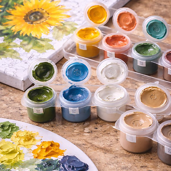 Nahaufnahme von geöffneten Farbtöpfchen mit Acrylfarben neben einer Malen-nach-Zahlen-Leinwand und einer Mischpalette – Symbolbild für Deckkraft, Konsistenz und typische Farbprobleme im Set.