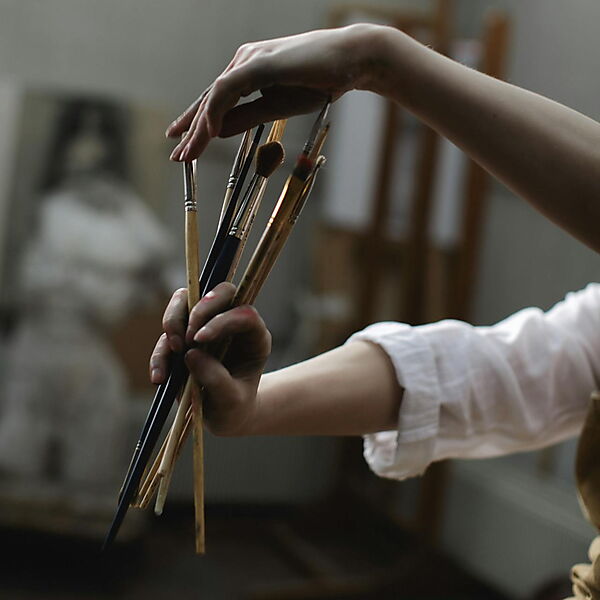 Nahaufnahme einer Person, die einen Pinsel hält – Symbolbild für den Einstieg und die ersten Schritte beim Malen nach Zahlen.