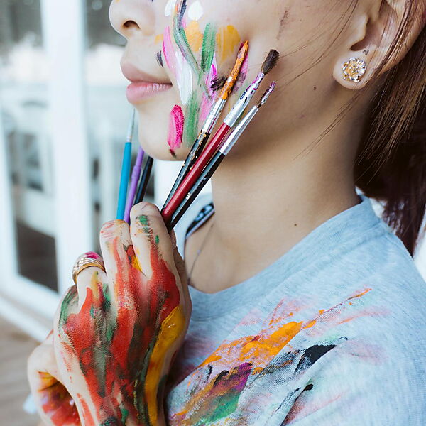 Nahaufnahme einer Hand mit bunten Farben – Symbolbild für einen kreativen Einstieg ins Malen nach Zahlen.