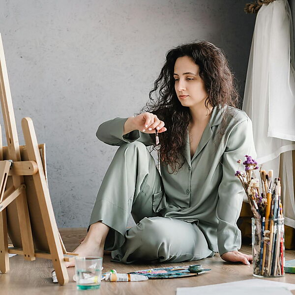 Frau sitzt am Tisch und malt konzentriert – Symbolbild für das Einschätzen von Detailgrad und Aufwand beim Malen nach Zahlen.