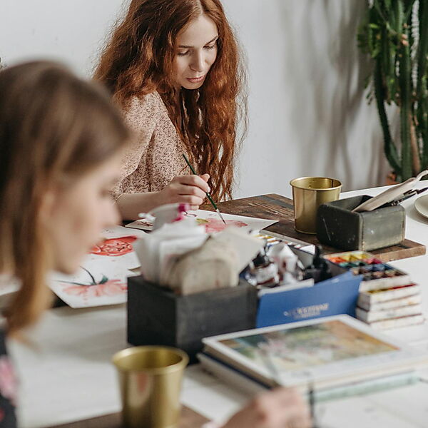 Frau arbeitet in einer Werkstatt an einem Malprojekt – Symbolbild für die Entwicklung von Malen nach Zahlen vom klassischen Set zur modernen, personalisierten Variante.