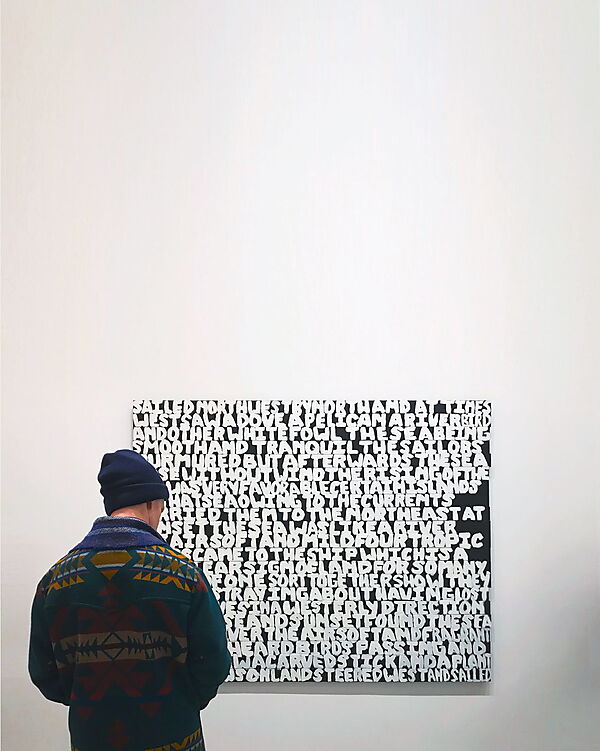 Ein Mann betrachtet aufmerksam ein modernes Gemälde in einer Kunstgalerie.