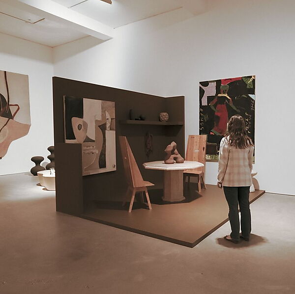 Frau steht mit Abstand in einer modernen Galerie und betrachtet mehrere Kunstwerke, ohne sich vorschnell auf eine Deutung festzulegen.