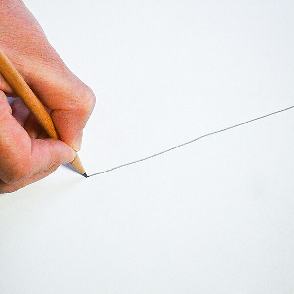 Hand zieht mit einem Bleistift eine lange Linie über weißes Papier