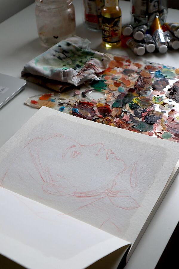 Skizzenblock mit Zeichnung, Pinseln und bunten Farben zeigt den Übergang vom Zeichnen zum Malen.