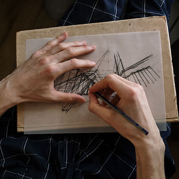 Hand skizziert mit einem Bleistift lockere Linien auf Papier und zeigt, wie Zeichnungen weniger steif wirken können.
