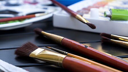 Nahaufnahme von Pinseln mit Farbe – Symbolbild für Pinselpflege und das Verhindern ausgefranster Pinselspitzen beim Malen.
