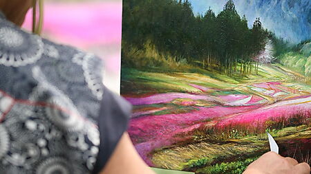 Person malt an einem Bild mit Pinsel und Farbe – Symbolbild für Reihenfolge, Schichten und sauberes Vorgehen beim Malen.