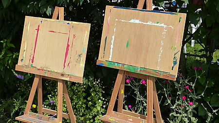 Staffelei mit Leinwand in einem hellen Raum – Symbolbild für Maluntergründe beim Malen nach Zahlen (Leinwand vs. Karton).