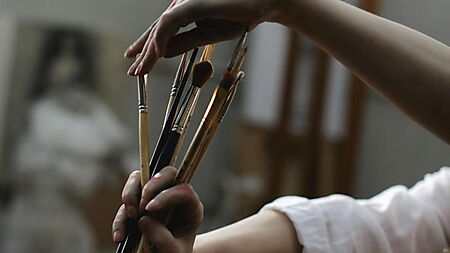 Nahaufnahme einer Person, die einen Pinsel hält – Symbolbild für den Einstieg und die ersten Schritte beim Malen nach Zahlen.