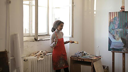 Frau malt konzentriert an einem Bild – Symbolbild für regelmäßige Etappen, Motivation und den Wiedereinstieg beim Malen nach Zahlen.