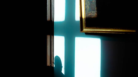 Ein Gemälde in einer Galerie wird von starkem Licht und Schatten getroffen und zeigt die Wirkung von Hell-Dunkel-Kontrasten.