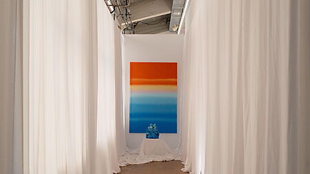 Langer Galerieflur mit weißem Stoff und einem farbigen abstrakten Bild am Ende zeigt Perspektive, Raumtiefe und Blickführung.