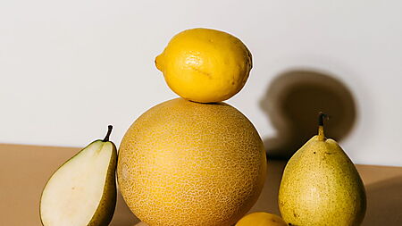Helles Stillleben aus Melone, Birnen und Zitrone mit deutlich sichtbaren Schlagschatten