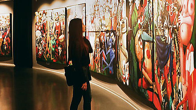 Frau betrachtet Bilder einer Ausstellung