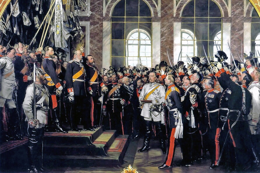Anton von Werners Historiengemälde zeigt Wilhelm I. auf einem Podest im Spiegelsaal von Versailles, umgeben von Fürsten, Offizieren und Bismarck.