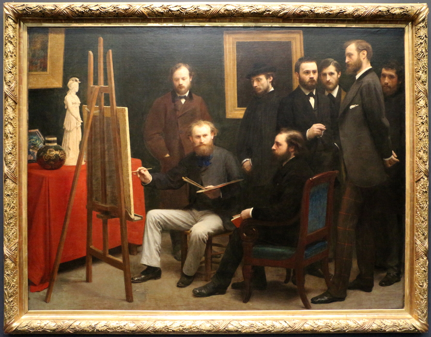 Acht dunkel gekleidete Männer versammeln sich in einem Atelier um Édouard Manet, der mit Palette und Pinsel vor einer Staffelei sitzt.