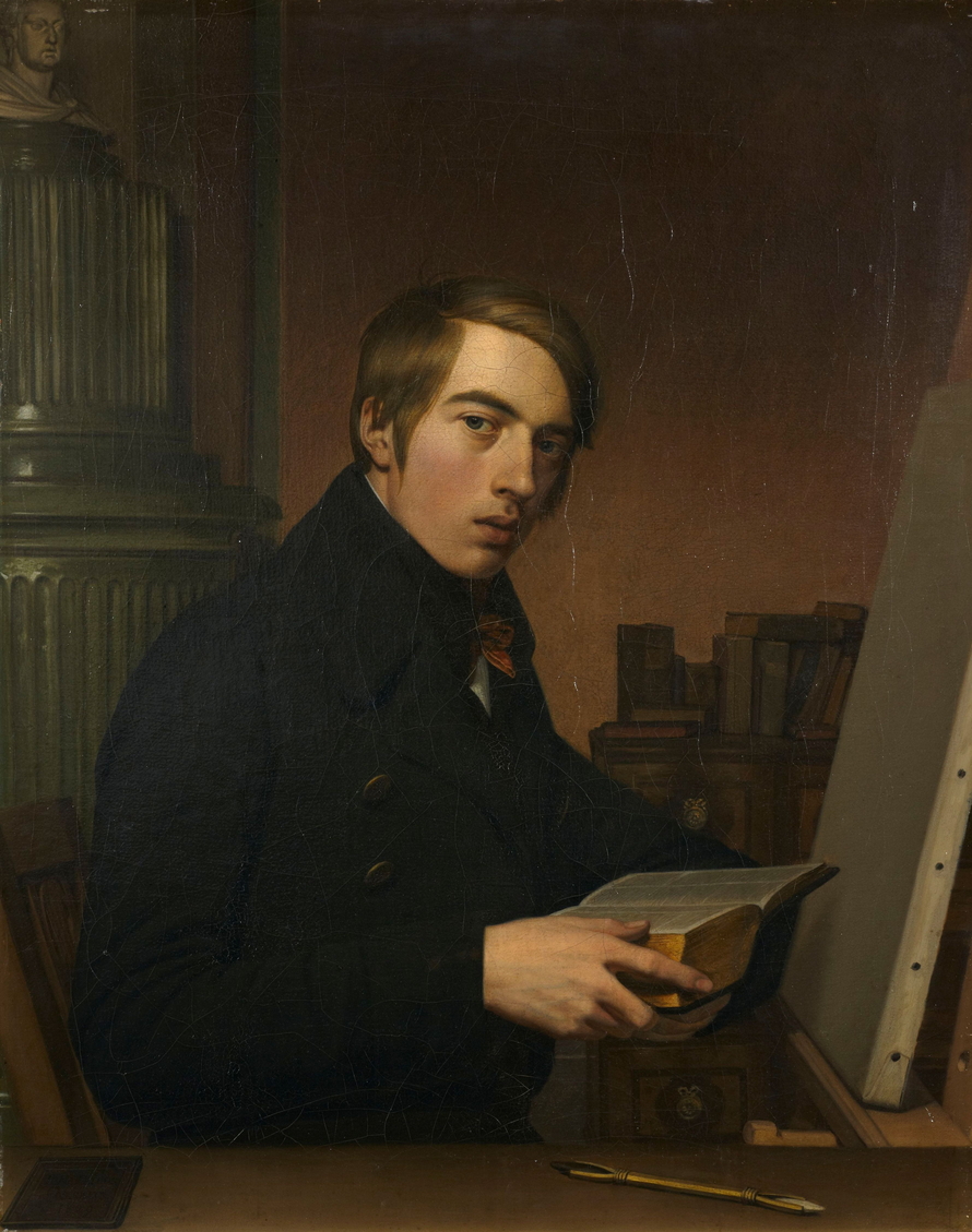 Johann Friedrich Overbeck sitzt mit einer geöffneten Bibel vor einer hellen, noch unbemalten Leinwand; Bücher, eine Büste und Zeichenstifte umgeben ihn.